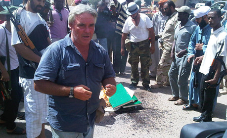 CNN's Ben Wedeman broadcasts live from Sabha while opposition fighters burn Gaddafi's green books