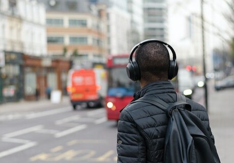 Man walking in city listening to headphones
