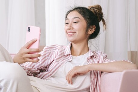 Young woman smiling looking at phone