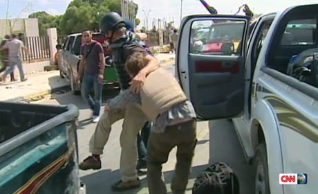 CNN producer Ian Lee is helped by colleagues after being shot in the ankle